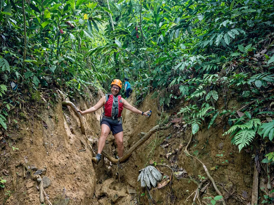 Guest in a helmet and life jacket descending the forest trail to the river, El Yunque