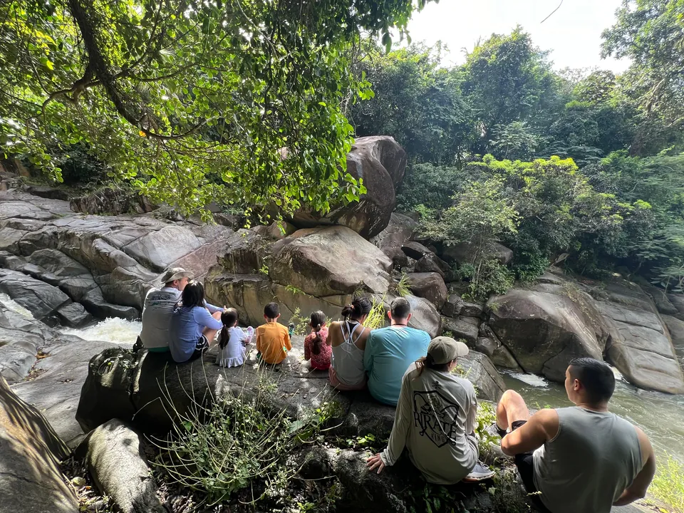 Family seated on the boulders above the river pools at Charco El Hippie, south side of El Yunque